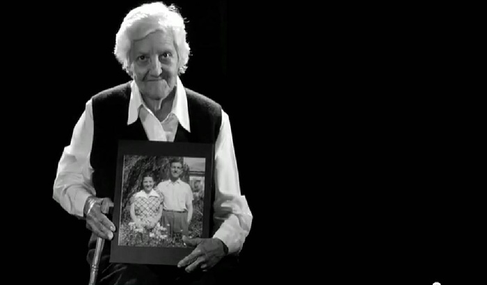 Ana holding a photo of her & her husband